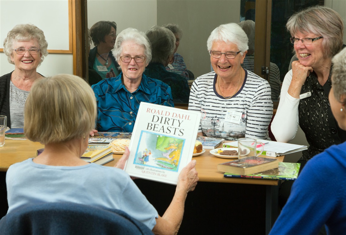 Picture of a group of women discussing a book at a Book club meeting. 