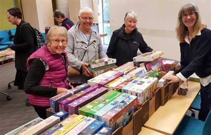 Picture of people attending the Jigsaw Puzzle Exhange at Whangārei Central Library in August 2023. 