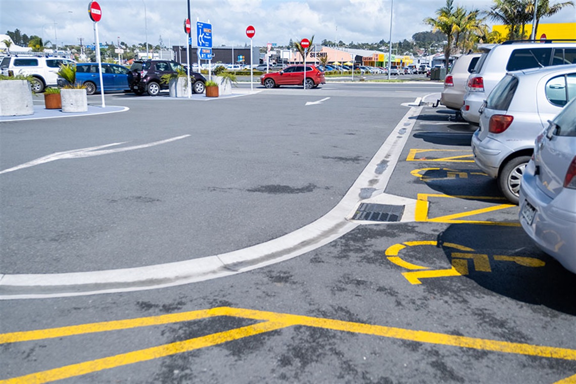 A photo of a carpark with yellow markings for disabled parking. 