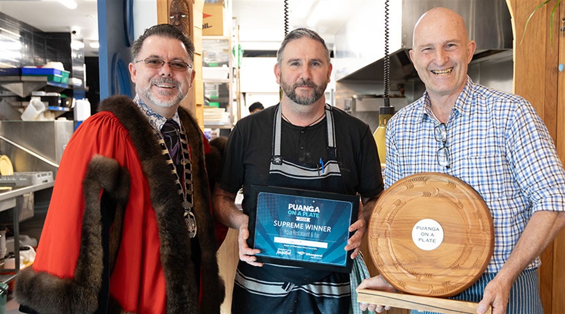 Mayor Vince Cocurullo presents the trophy for supreme winner of the inaugural Puanga on a Plate competition to Aqua owners Craig Estick and Steve O’Shea.