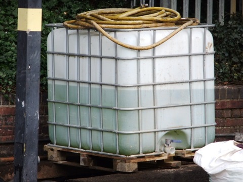 Image of a water tank with yellow pipe on the top. 