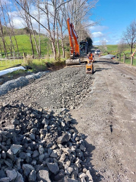 Photo showing heavy machinery repairing a straight gravel road - Ody Road in Whangarei Heads. 