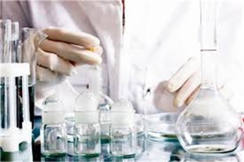 Photo of person testing a fluid in a laboratory. 