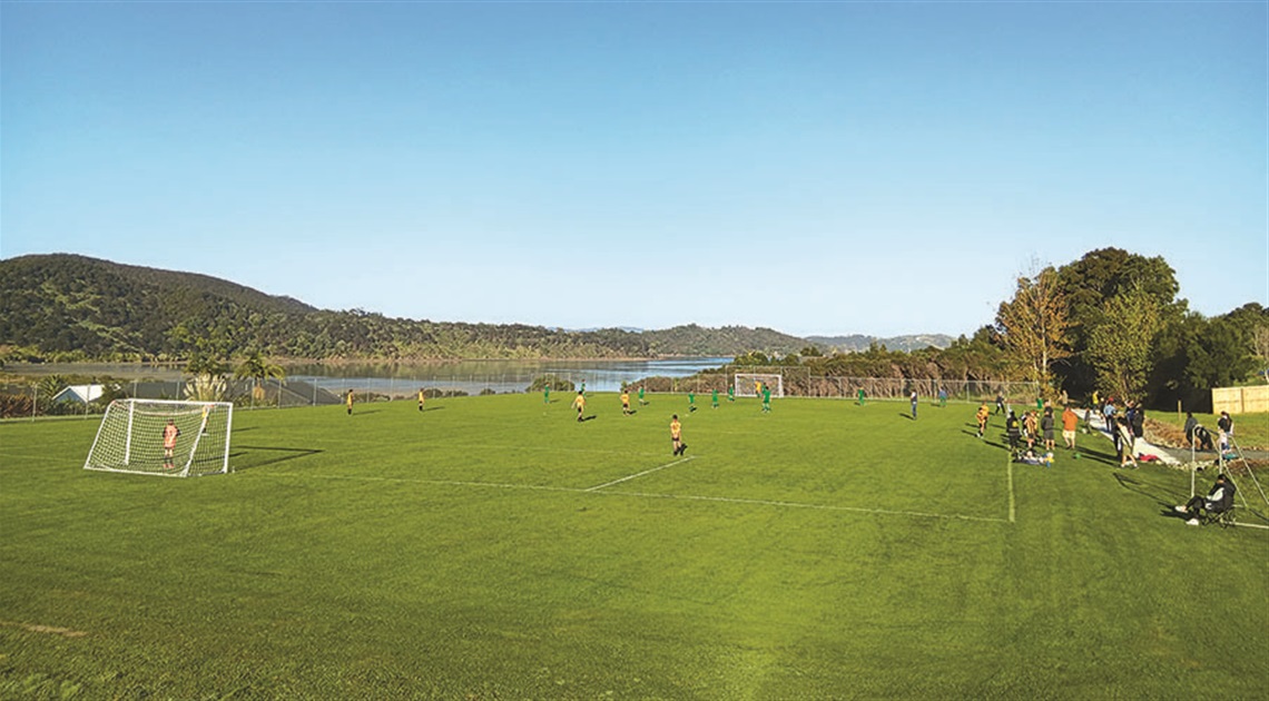 Footballers enjoy one of the first games at Anderson Park, Parua Bay on a gleaming, early winter day.]