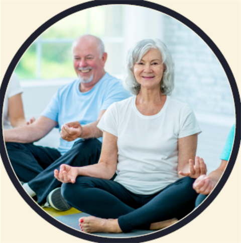 Image of two people sitting cross legged on the floor. 