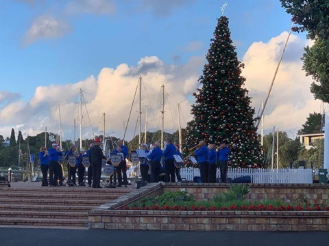 Image of the brass band playing at the town basin. 