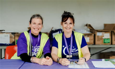 Image of two volunteers taking registrations. 