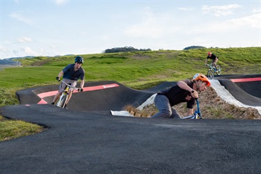 Cyclists riding on the pump track at Bike Park on Pohe Island.