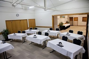 Bounty Room classroom layout, alternate corner angle with tables and chairs setup facing the front.