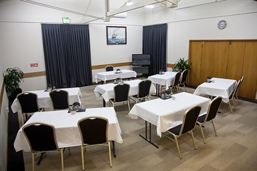 Bounty Room classroom layout, bottom left back angle with chairs and tables setup in a well-lit room.