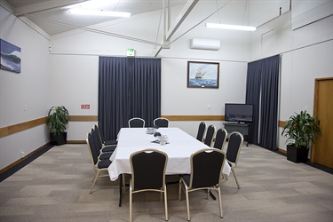 Bounty Room in a meeting layout, wide angle shot with tables and chairs setup.