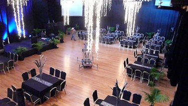 Exhibition Hall cocktail layout, high angle with lights hanging from the ceiling with tables and chairs setup.