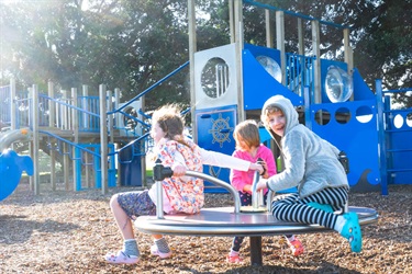 Children on the play equipment at the playground at Marsden Bay reserve, One Tree Point.