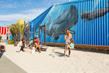 Children and parents play in the sand pit at Pocket Park.