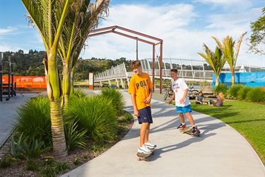 Two kids skate through Pocket Park.