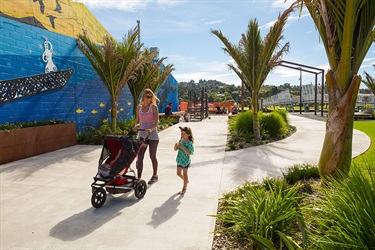 A woman pushes a pram through Pocket Park.