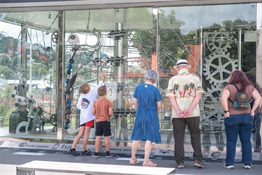 A crowd gathers in front of the rolling ball clock.